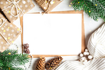 Merry Christmas and happy New year. Mockup with postcard and branches of a Christmas tree on white background.Background with copy space. Selective focus. Top view. Christmas background.