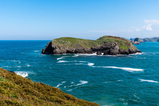 Scenic view of sea against blue sky in rocky coast