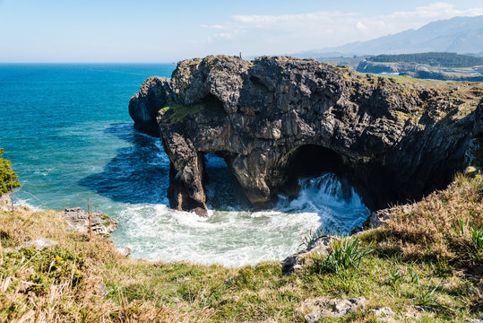 Scenic view of sea against blue sky in rocky coast