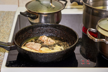 Frying chicken in a pan. Cooking potatoes.