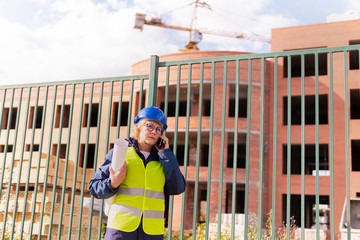 A woman Builder at a construction site inspects a house made of brick
