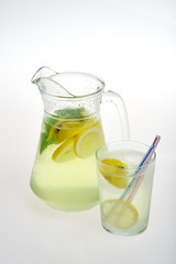 Lemonade jug with ice and glass on a white background. Isolated.