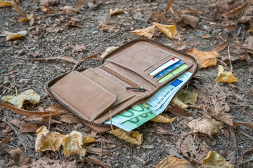 Lost leather wallet with money on street