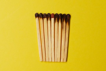 Symbol of danger with matches on yellow  background top view , pile of burnt matches  arrange in a...