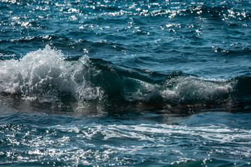 sea wave splashes over stone