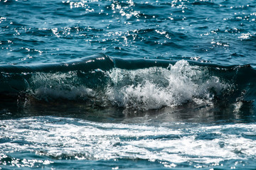 sea wave splashes over stone
