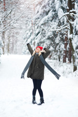 Fototapeta na wymiar Joyful woman dancing in winter forest
