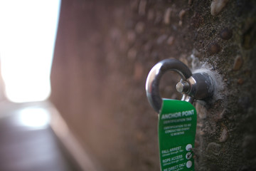 Picture of industrial rope access working at height fall arrest, abseiling stainless ring 16 MM dimension certifies anchor point installed on concrete wall  construction building site, Australia 