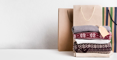 Warm sweaters with patterns and tag for text laying on white