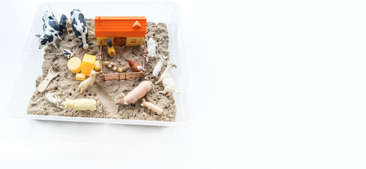 Montessori material. Children's hands play an animal figure. Kinetic sand. Copy space