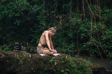 Yoga practice and meditation in nature. Man practicing near river