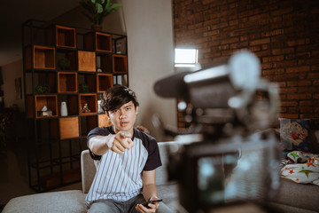 asian young man vlogger make video review about of new type smartphone series with recorded with...