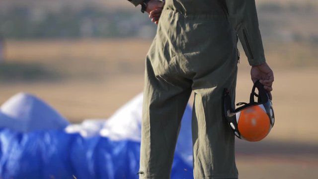 paraglider pilot with helmet on wing background