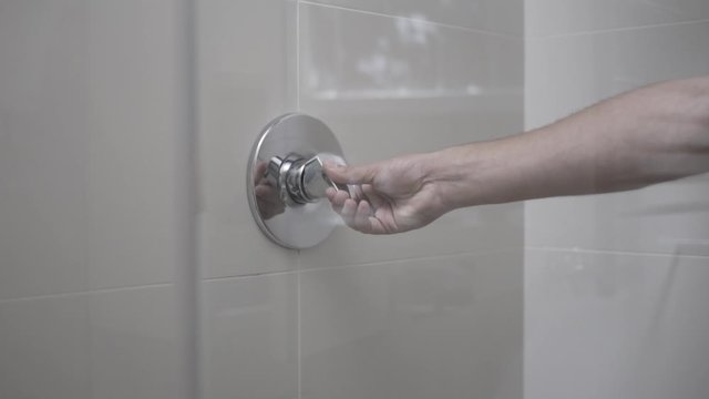 slow pan across bathroom showing a hand lifting the sower tap handle
