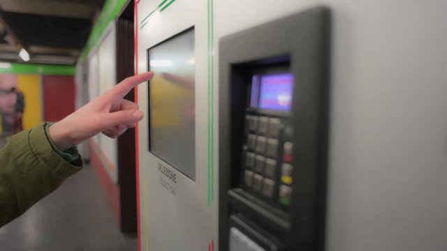 Hand typing on a screen of ticket machine