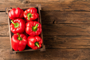 Overhead shot of red sweet paprika in box on old wooden background with copyspace. Bell pepper. Top view