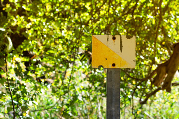 Yellow and white metal sign of mountain and trails