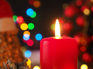 Burning Advent candle with Christmas lights