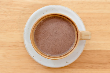 Close up a cup of hot chocolate on wooden table background at coffee shop.