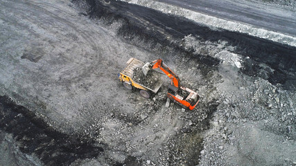 Coal mining in a quarry. A hydraulic excavator loads a dump truck.