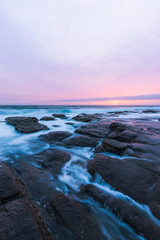 Water flowing through the rocks in an overcast sunrise.