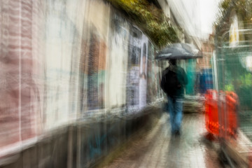 Long exposure of pedestrians walking along the street - intentional camera shake to introduce an impressionistic effect and light trails