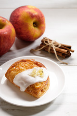 piece of cinnamon apple pie on a white plate with fresh apple in background, autumn food concept