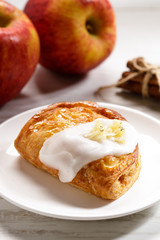 piece of cinnamon apple pie on a white plate with fresh apple in background, autumn food concept