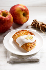 piece of cinnamon apple pie on a white plate with fresh apple in background, autumn food concept