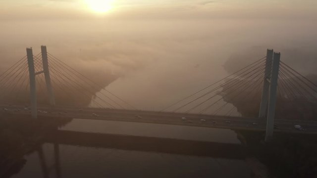 Siekierkowski Bridge, Warsaw, Poland.  Aerial view of the sost with the movement of cars across the Vistula River.  Foggy morning, sunrise and a beautiful view of the city infrastructure.