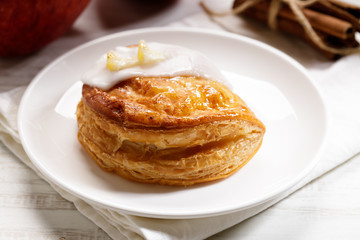 piece of cinnamon apple pie on a white plate with fresh apple in background, autumn food concept