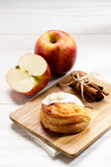 Naklejka na ściany i meble piece of cinnamon apple pie on a wooden board with fresh apple in background, autumn food concept