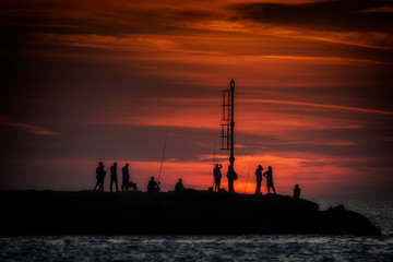 Sunset on the pier with silhouettes of fishermen in Italy - Tramonto sul molo con sagome dei pescatori in Italia