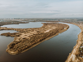 Elongated island on the spring river. Big wide river. Panorama of the river.