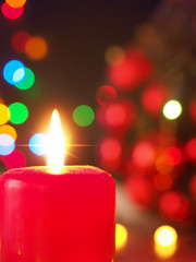 Burning Advent candle with Christmas lights