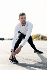 fitness, sport, training and lifestyle concept - man stretching outdoors