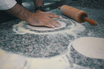 Fototapeta na wymiar Gourmet chef preparing Italian bread with rolling pin