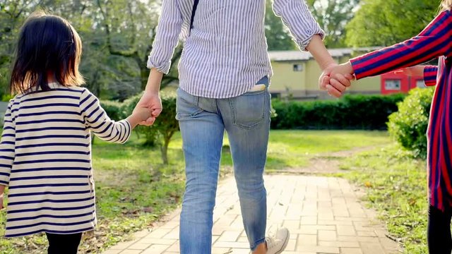 公園で手を繋いで歩く日本人の親子