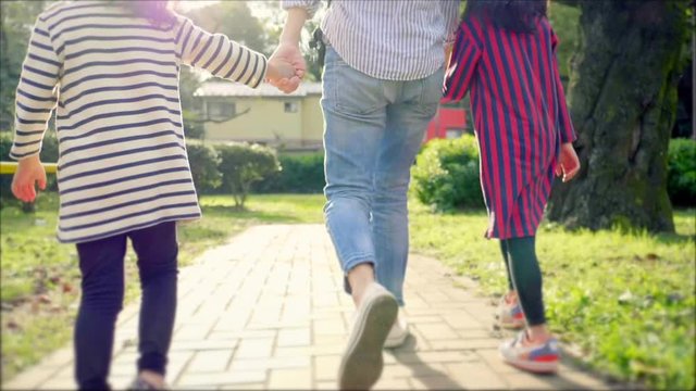公園で手を繋いで歩く日本人の親子