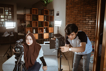 young couple vlogger preparing camera and equipment to create their vlog content at home
