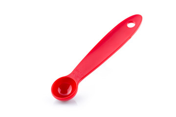 red measuring spoon of plastic on white background.