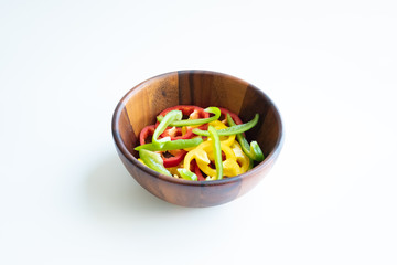 Sliced sweet pepper in wooden bowl