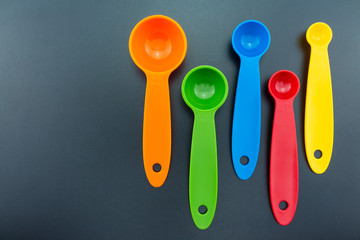 a set of measuring spoon of plastic on black background.