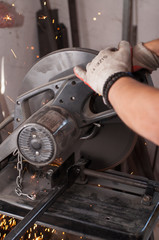 Fototapeta na wymiar Cutting metal with grinder in workshop. Sparks while grinding iron. Cutting machine.