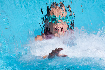 portrait of a female behind a water fall in a swimming pool