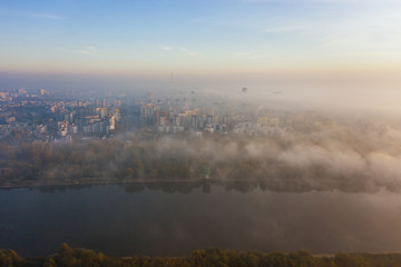 Naklejka premium 4K. Drone Shot. Morning fog or fog over a village in a suburb of Warsaw in the countryside with an agricultural field in Poland. 