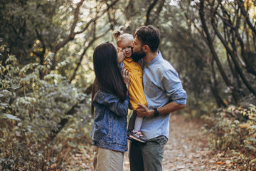 happy young family: stylish father, beautiful mom and sweet little daughter spend a day together on...