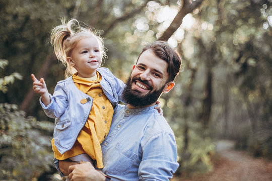 happy father and daughter playing while walking in a beautiful autumn park. Ideal weekend father with his little daughter. selective focus, noise effect
