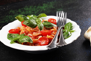 Pasta orecchiette. Plate of delicious orecchiette with tomato sauce garnished with parmesan cheese and basil on rustic background