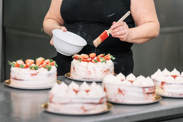 Obraz na płótnie Canvas Unrecognizable woman Pastry Chef making delicious tart at confectionery shop .